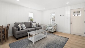 A modern living room with a grey sofa, patterned armchair, and a coffee table.
