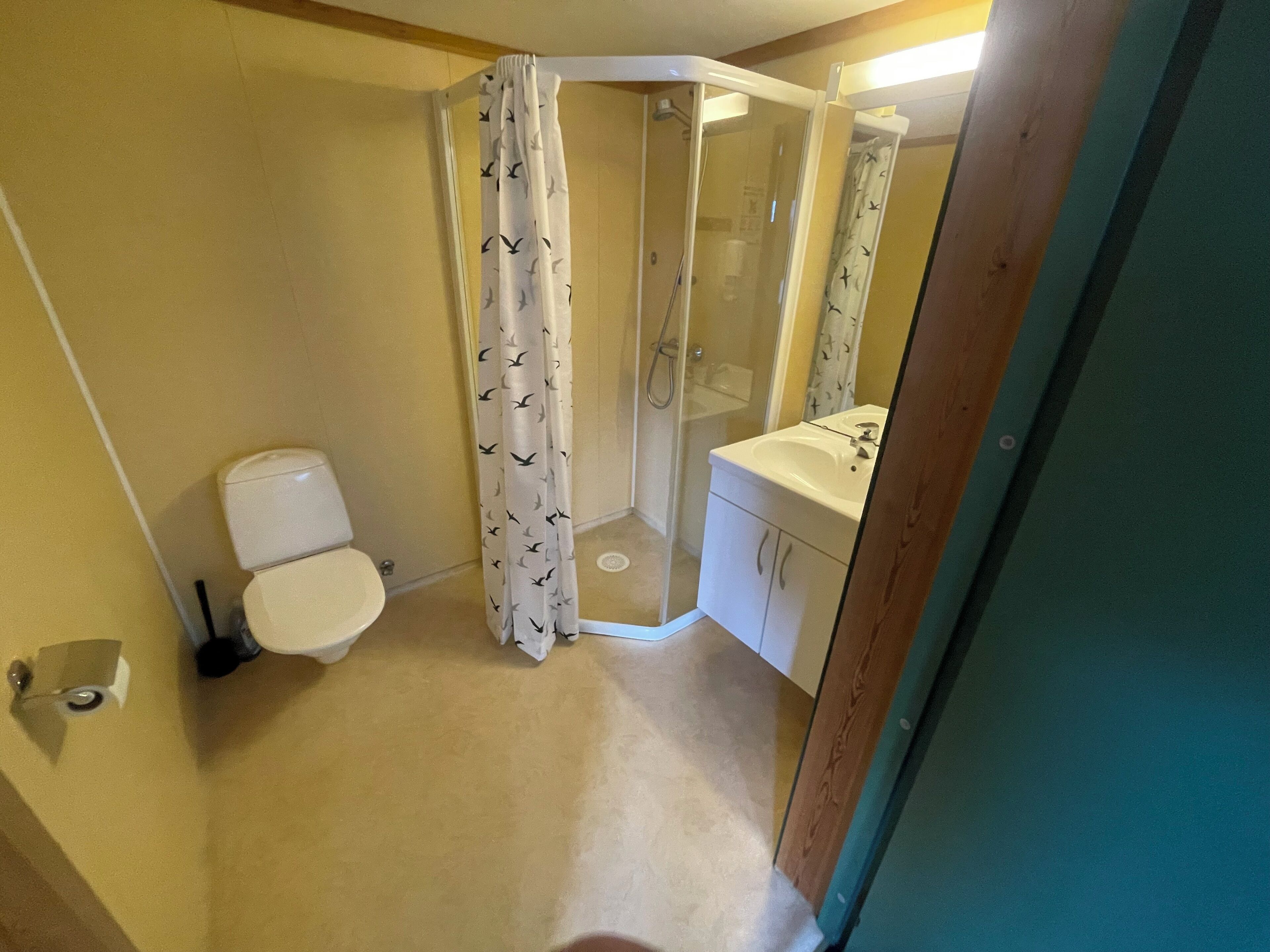 Ein kleines Badezimmer mit Toilette, Duschkabine und Waschbecken.