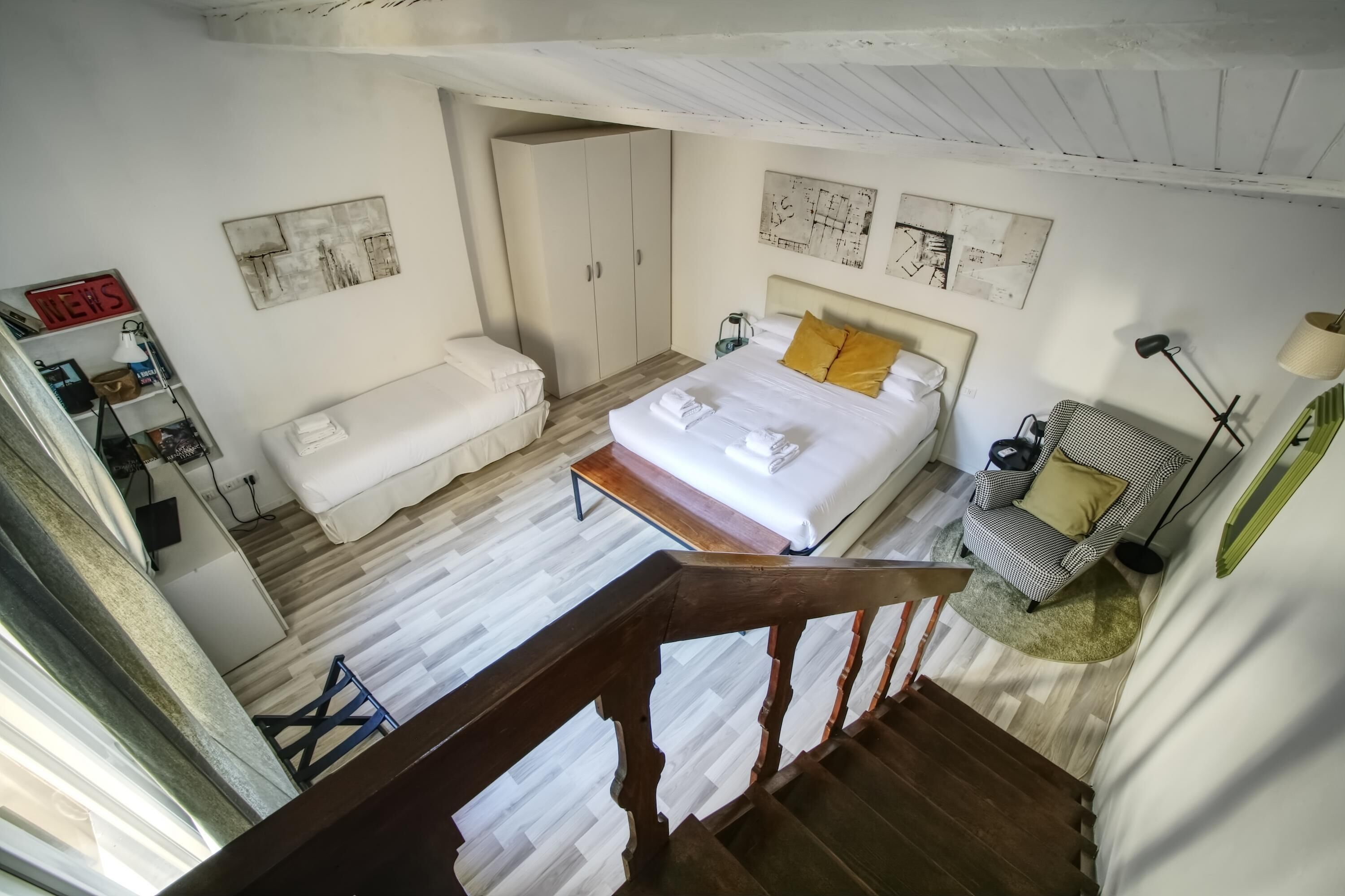 Un dormitorio con cama, una silla, un escritorio y un armario.