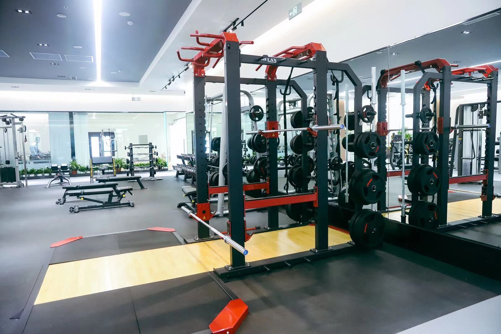 Uma academia moderna com equipamentos de musculação, espelhos e um espaço amplo e bem organizado.
