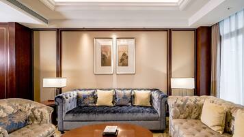 Uma sala de estar bem equipada com um sofá grande, duas poltronas e uma mesa de centro.