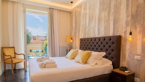 Une chambre d’hôtel avec un grand lit, une chaise, une table et une vue sur l’extérieur.