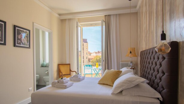 Une chambre d’hôtel avec un lit, une vue sur l’extérieur, une chaise et une lampe.