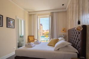 Une chambre d’hôtel avec un lit, une vue sur l’extérieur, une chaise et une lampe.