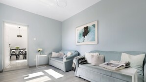 A modern living room with two light blue sofas, a white coffee table, and a framed picture on the wall. - Elite Apartments Sopot Seaside (Sopot)