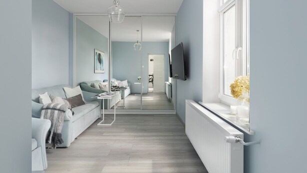A modern living room with a sofa, a coffee table, and a TV mounted on the wall. - Elite Apartments Sopot Seaside (Sopot)