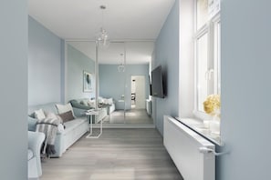 Un salon moderne avec un canapé, une table basse et un téléviseur fixé au mur.