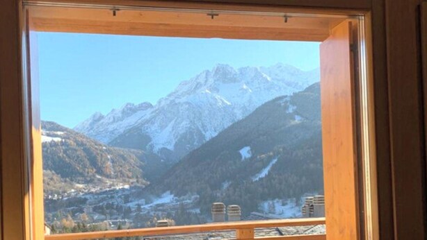 A mountain view through a window with a wooden frame. - Villa Nice View in Pontagna (Temu)