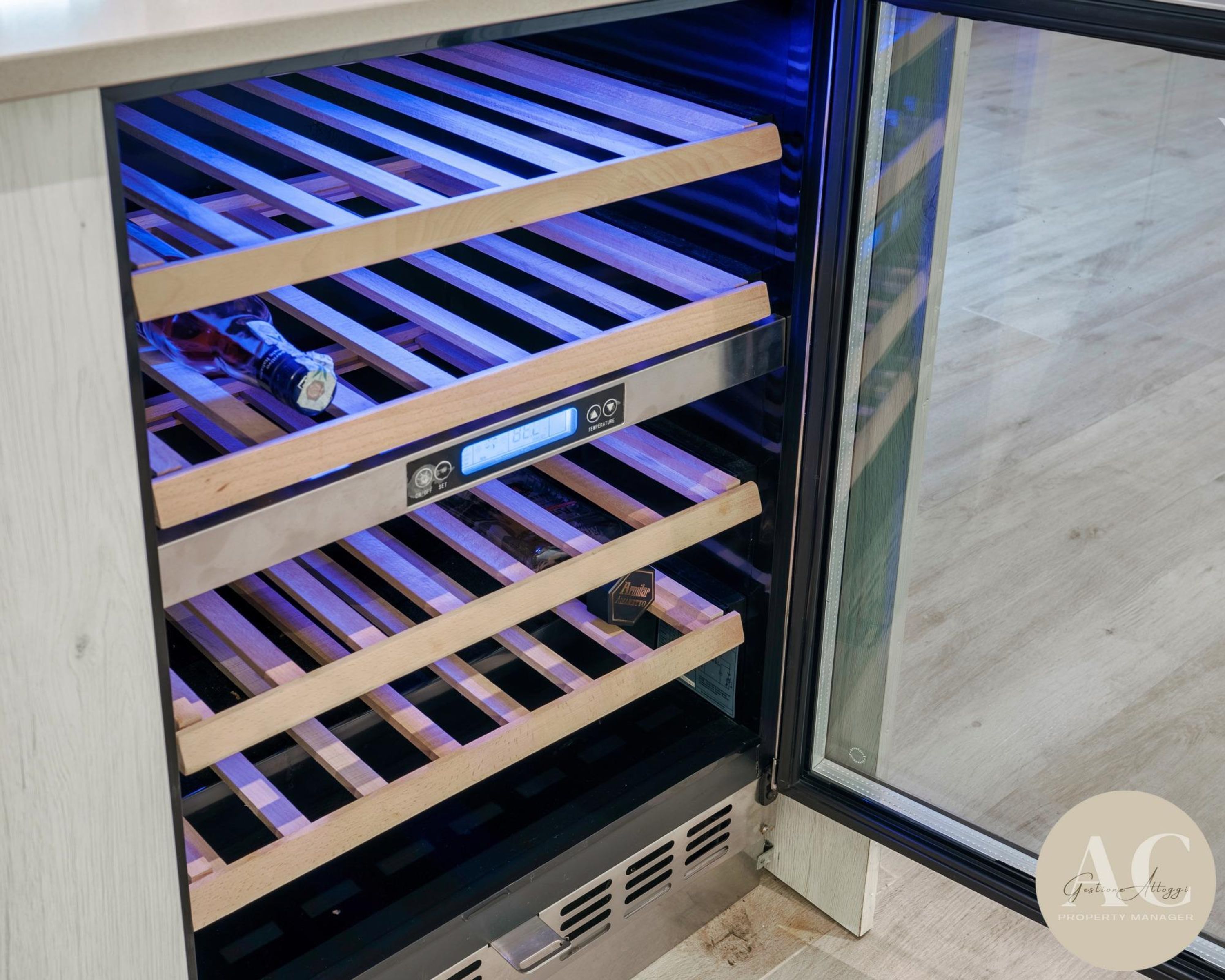 Un refrigerador para vino con varias repisas y una pantalla digital.