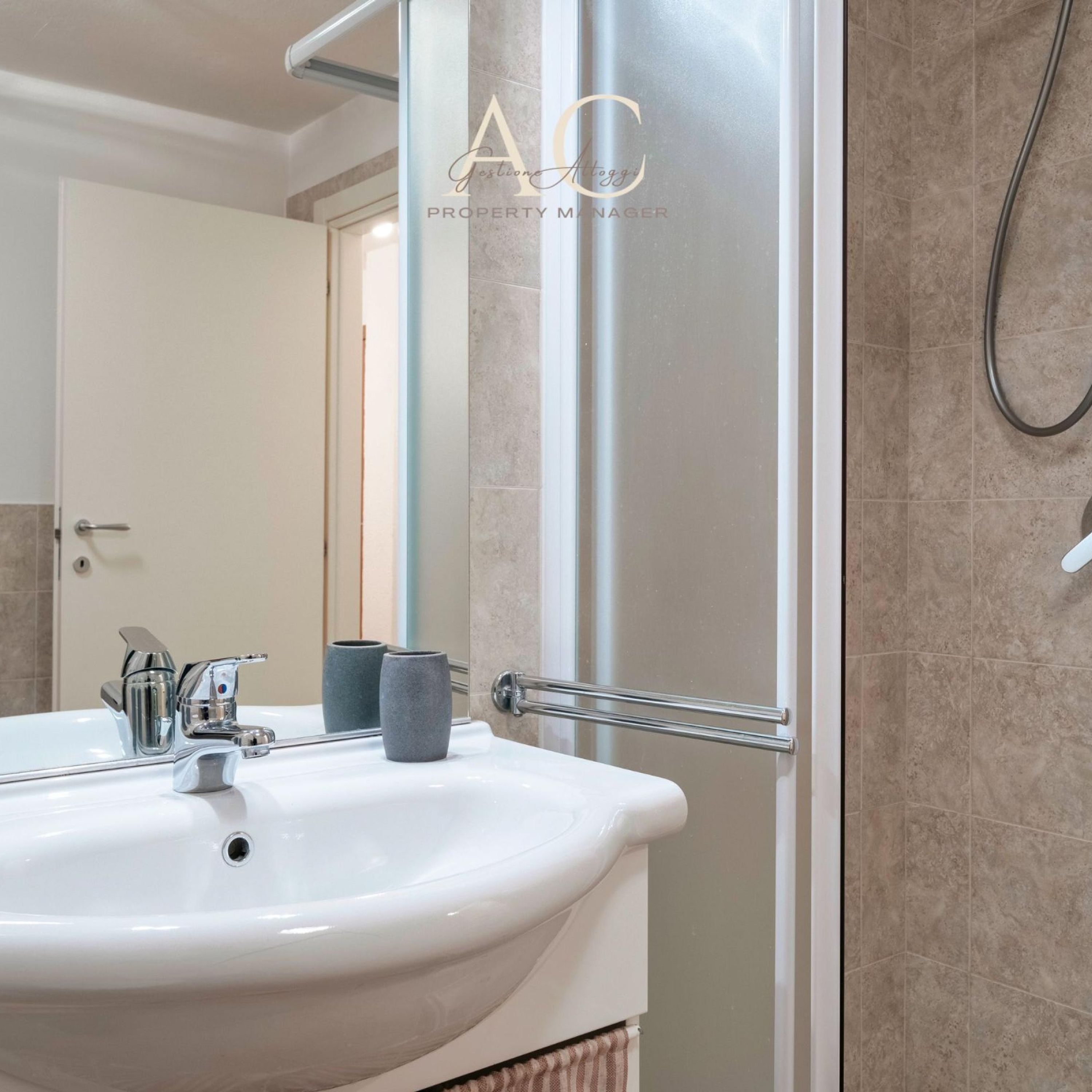 A bathroom with a white sink, chrome faucet, and a towel rack.