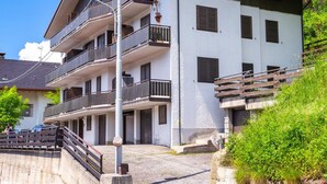 Ein mehrstöckiges Gebäude mit Balkonen, einer Treppe und einem Parkplatz.