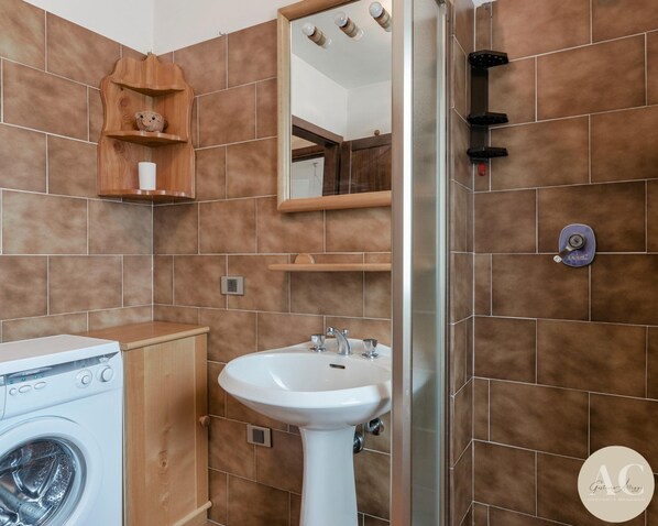 A bathroom with a washing machine, a sink, and a mirror. - Uno Sguardo Sulle Cime (Vione)