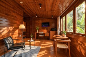 A wooden interior with a dining area, a TV mounted on the wall, and a window with a view of greenery. - Nexus House Thao Dien (Ho Chi Minh City)