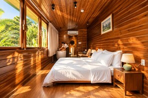 A wooden cabin bedroom with a large bed, a nightstand, a lamp, and a view of the outdoors. - Nexus House Thao Dien (Ho Chi Minh City)