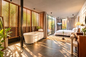 A modern bedroom with a bathtub, a bed, and a television. - Nexus House Thao Dien (Ho Chi Minh City)