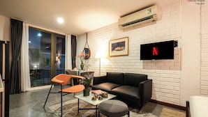Ein modernes Wohnzimmer mit einer Couch, einem Couchtisch und einem an der Wand befestigten Fernseher.