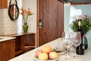 A kitchen counter with a plate of fruit, a wine bottle, and glasses. - Nexus House Thao Dien (Ho Chi Minh City)