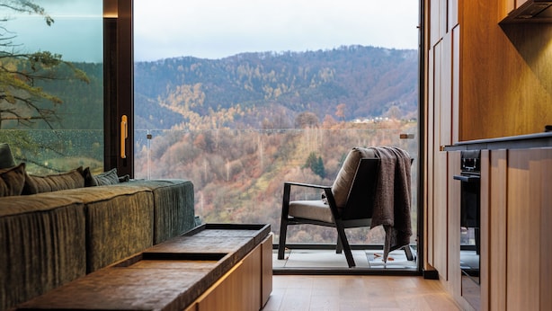 A modern interior with a sofa, a chair, and a wooden bench.