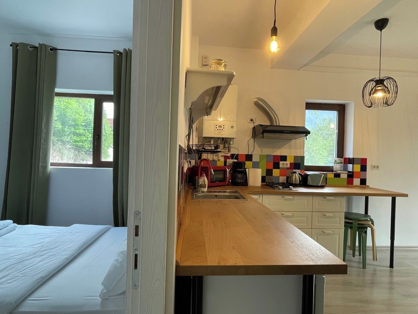 Une cuisine de taille réduite, dotée d’un plan de travail en bois, d’un évier, d’une cuisinière et d’une fenêtre.