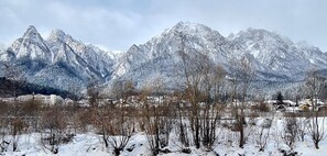 A mountainous landscape with snow-covered peaks and a town in the valley.