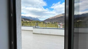 Un balcón con vistas a montañas y un pueblo.
