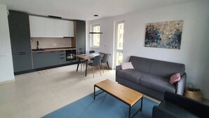 A modern apartment with a kitchen, dining area, and living room.