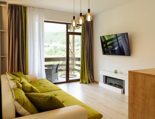 Een moderne woonkamer met een bank, een televisie en een open haard.