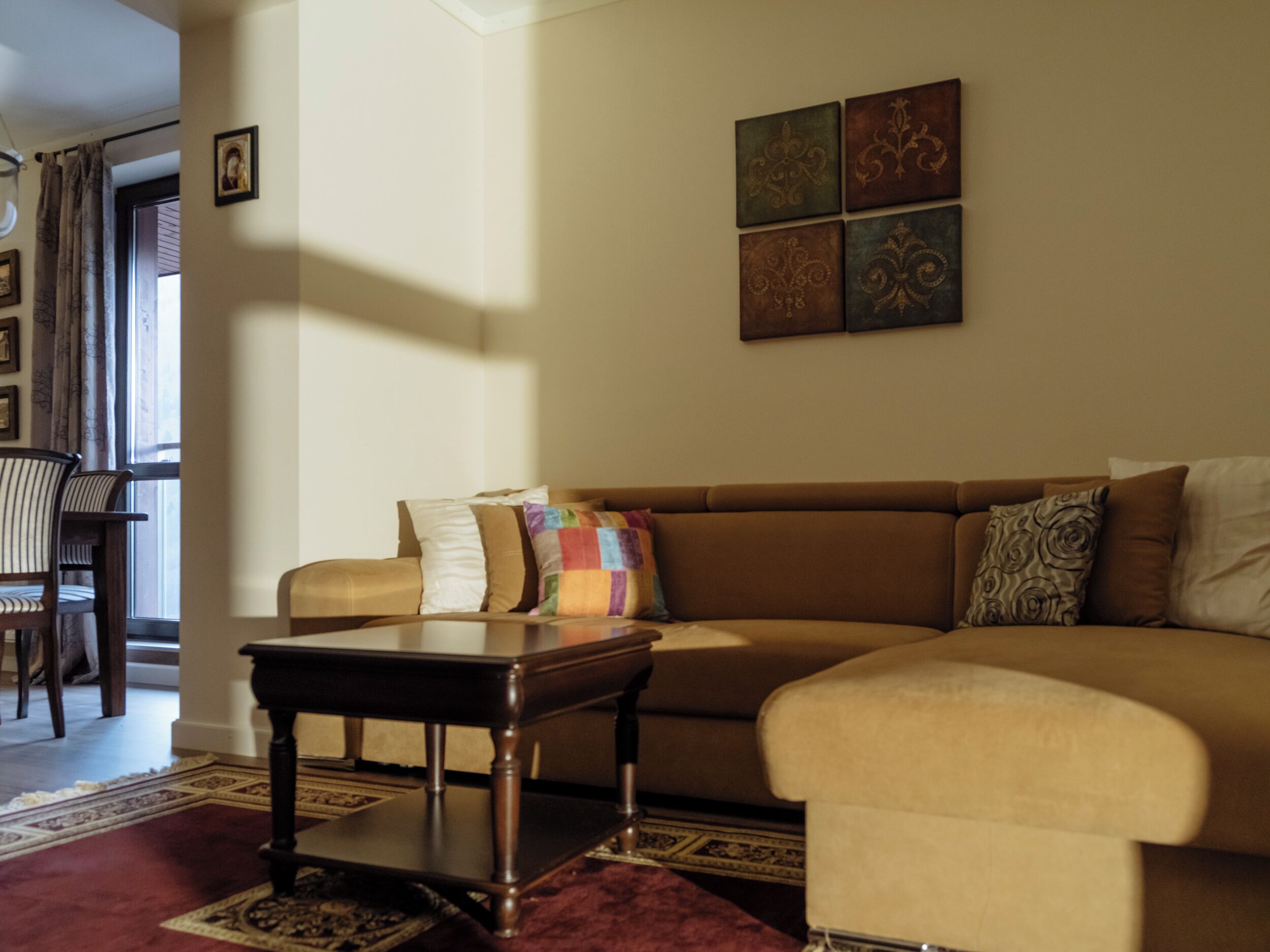 A living room with a sofa, a coffee table, and a patterned rug.