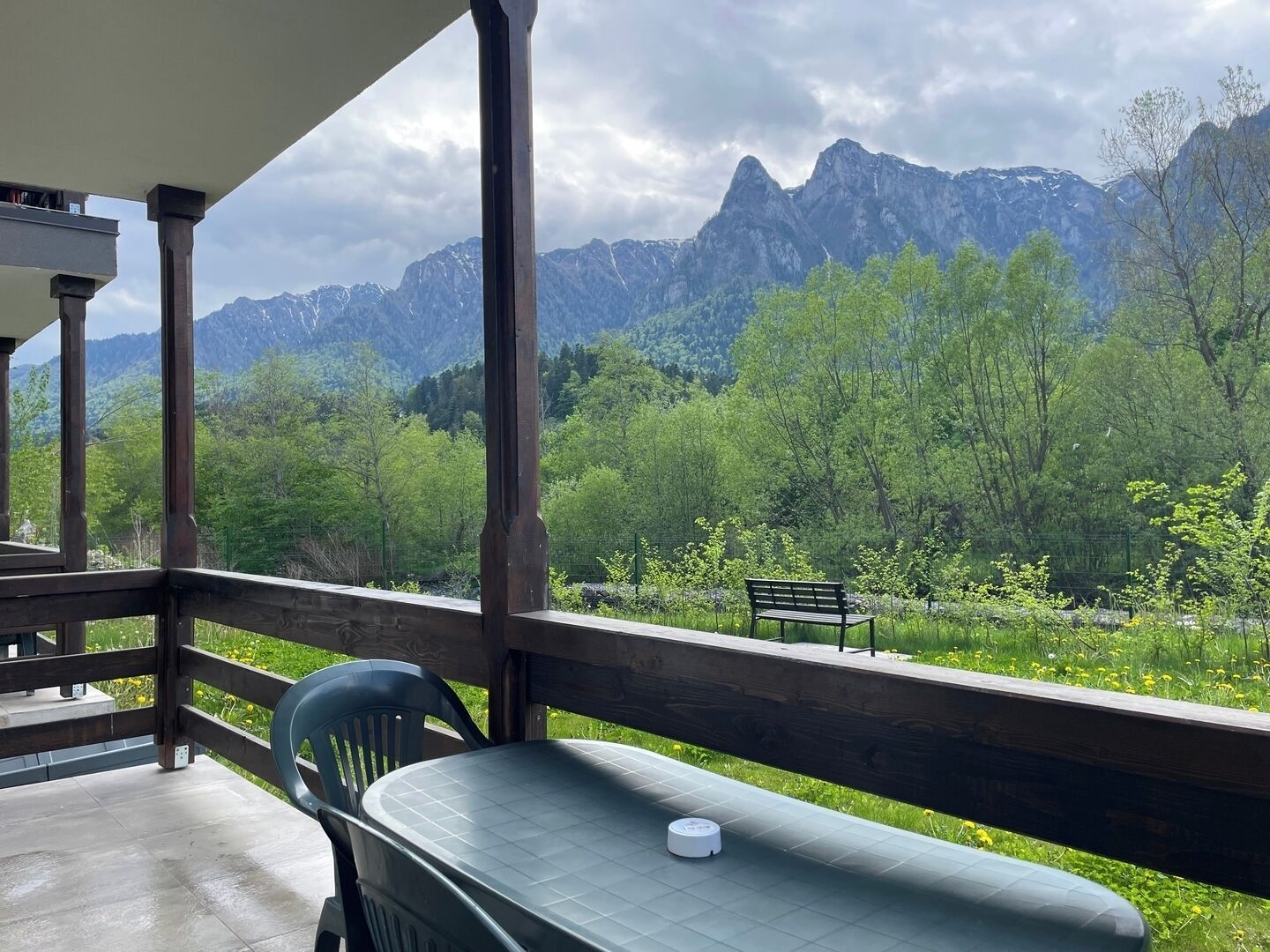 Un balcón con mesa y sillas, con vistas a un paisaje montañoso.