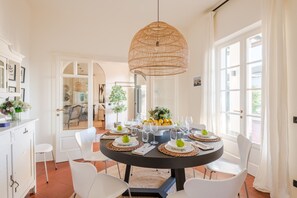 A dining area with a round table set for six, surrounded by white chairs, a black tablecloth, and woven placemats. - Villa Desiree in Pietrasanta (Pietrasanta)