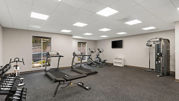 A gym with treadmills, elliptical machines, and free weights.