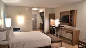 A hotel room with two beds, a desk with a chair, a television mounted on the wall, and a kitchenette area. - Mainstay Suites Gatlinburg TN (Gatlinburg)