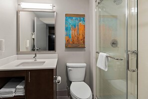 A bathroom with a sink, toilet, and glass shower enclosure. - Mainstay Suites Gatlinburg TN (Gatlinburg)