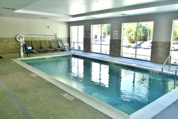 An indoor swimming pool with clear lane markings, a changing room area, and large windows offering views of the outside. - Mainstay Suites Gatlinburg TN (Gatlinburg)