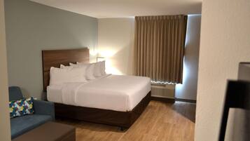 A hotel room with a bed, a desk, and a chair.
