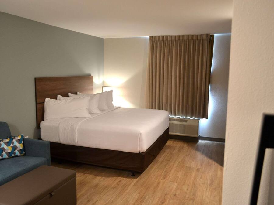 A hotel room with a bed, a desk, and a chair.