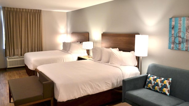 A hotel room with two beds, a sofa, and a wall-mounted artwork. - Mainstay Suites Gatlinburg TN (Gatlinburg)