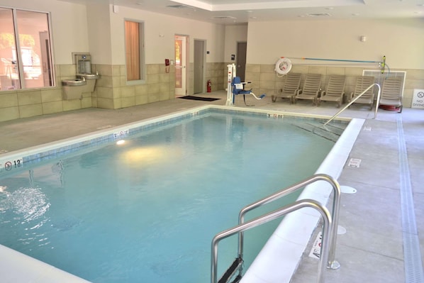 An indoor swimming pool with clear water, a diving board, and a lifeguard chair. - Mainstay Suites Gatlinburg TN (Gatlinburg)