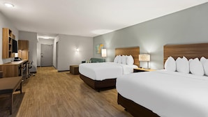 A hotel room with two beds, a desk, a chair, a lamp, and a TV. - Mainstay Suites Gatlinburg TN (Gatlinburg)