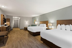 A hotel room with two beds, a desk, a chair, a lamp, and a TV. - Mainstay Suites Gatlinburg TN (Gatlinburg)