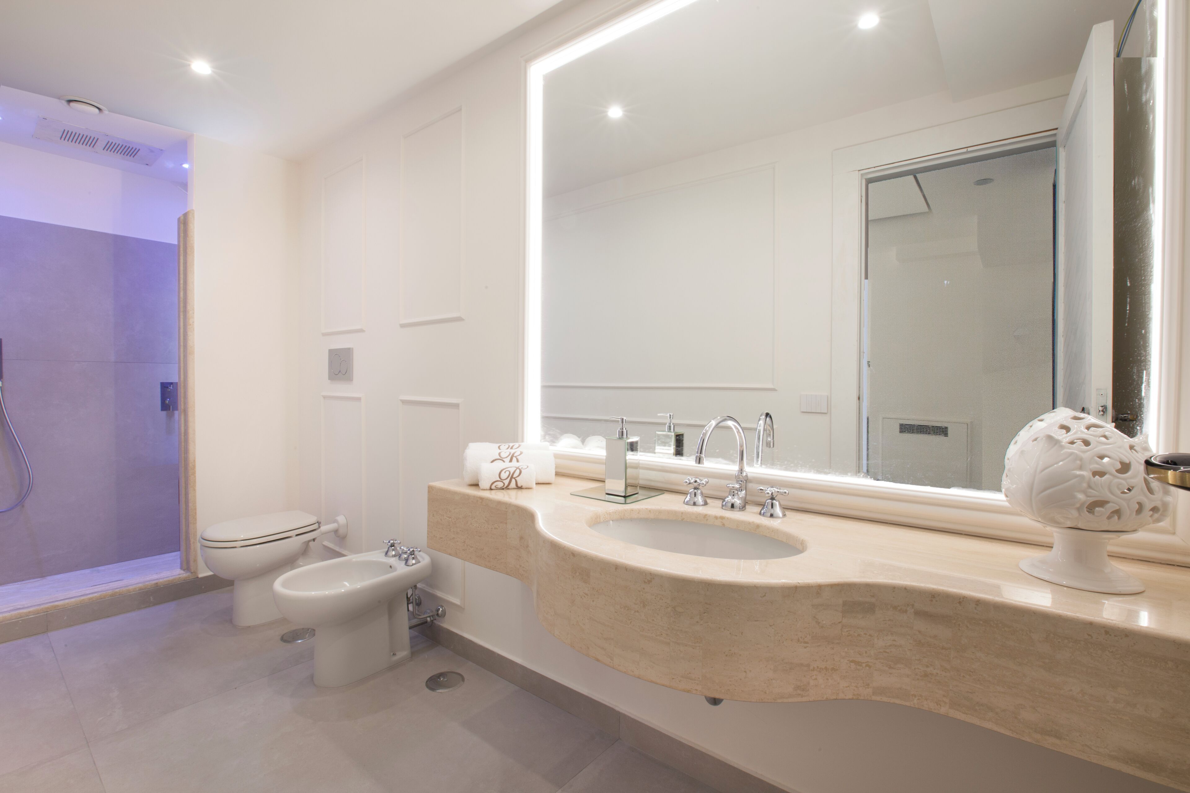 Ein modernes Badezimmer mit Badewanne, Toilette, Bidet und Waschbecken.