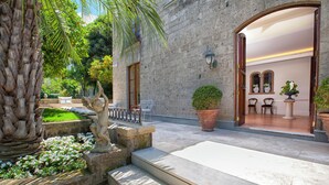 A stone building with a courtyard, steps leading to an entrance, and outdoor seating.