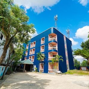 A multi-story building with balconies, a clear sky, and a telecommunications tower. - Mayfa Hotel (Phuket)