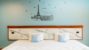 Une chambre d’hôtel avec une tête de lit en marbre, deux oreillers, un lit et un motif décoratif représentant une vue de la ville avec des oiseaux.