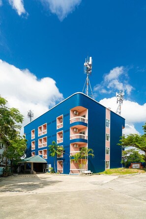 A multi-story building with balconies, a satellite dish, and a small covered area in front. - Mayfa Hotel (Phuket)