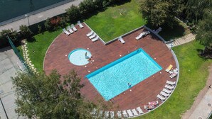 An aerial view of a rooftop pool area with a rectangular pool, surrounded by lounge chairs and a circular hot tub. - Liiiving - Douro Riverside Apartment (Gondomar)