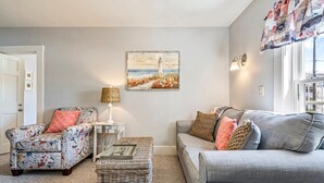 A living room with a sofa, armchair, and a small table with a lamp. - Beautiful inn, Lighthouse Landing. #5 Beach Rose (Ogunquit)