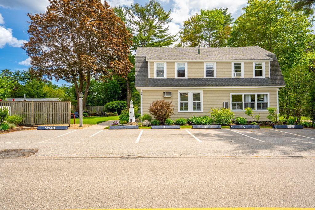 A two-story building with a parking lot in front.