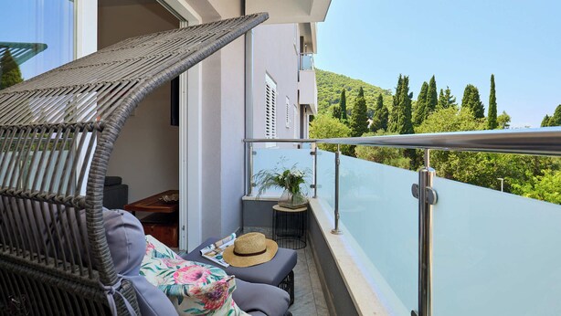 A balcony with wicker furniture, a hat, and a plant. - Hedera Estate, Hedera A35 (Dubrovnik)