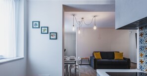 Une cuisine moderne dotée d’un espace de travail fonctionnel, d’un coin repas et d’un salon avec un canapé et des coussins.
